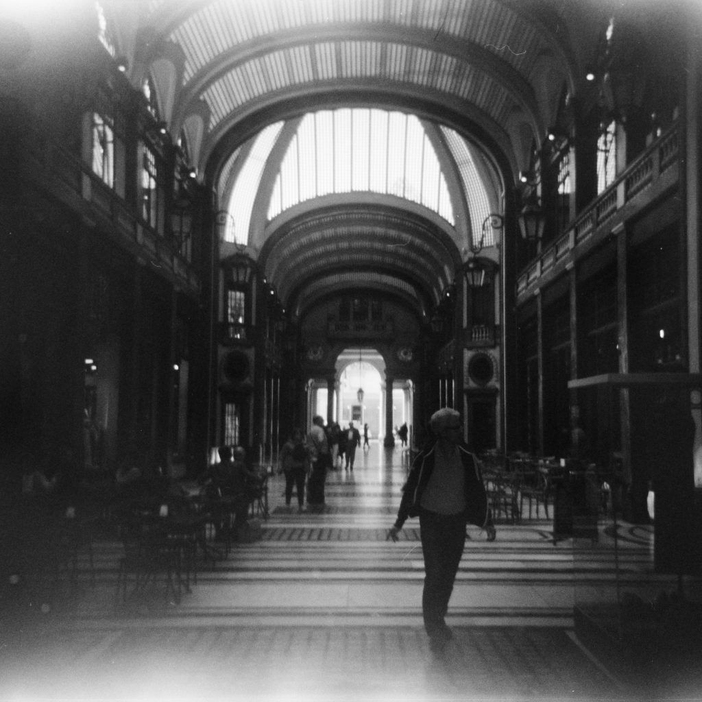 a Gallery's hallway with people walking in it