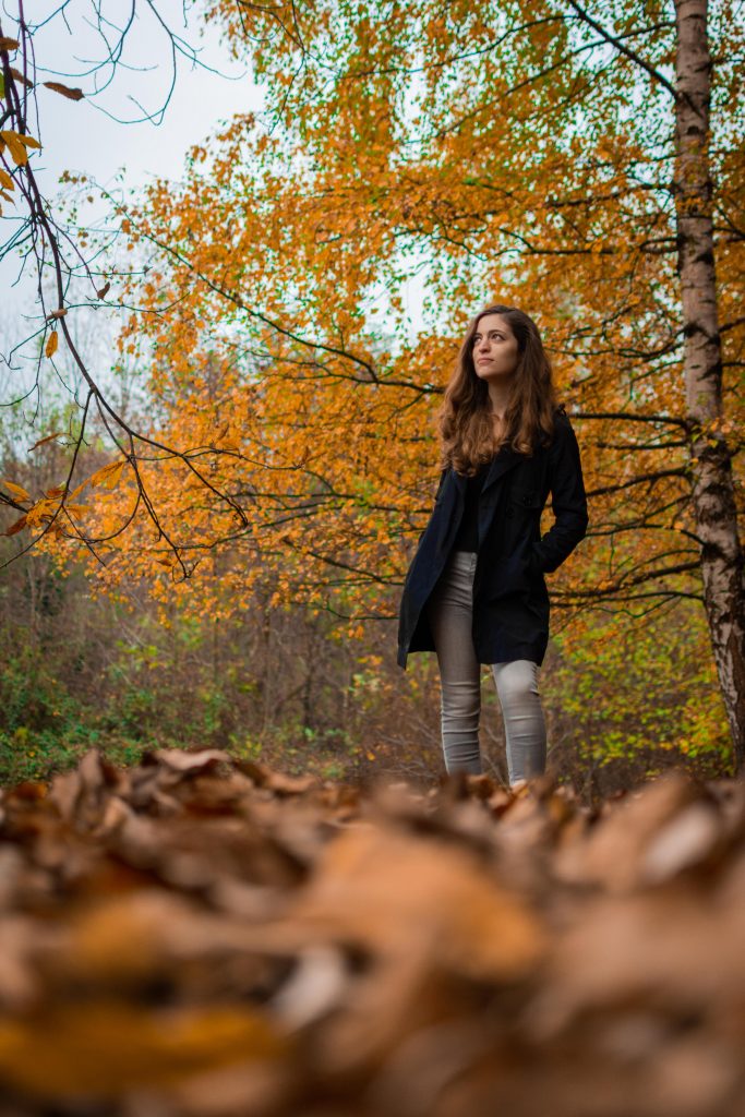 A girl dressed in black in the woods during fall