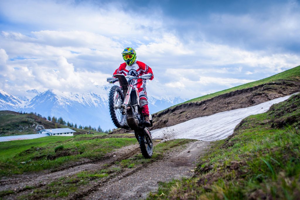 A man on a dirt bike doing a wheelie