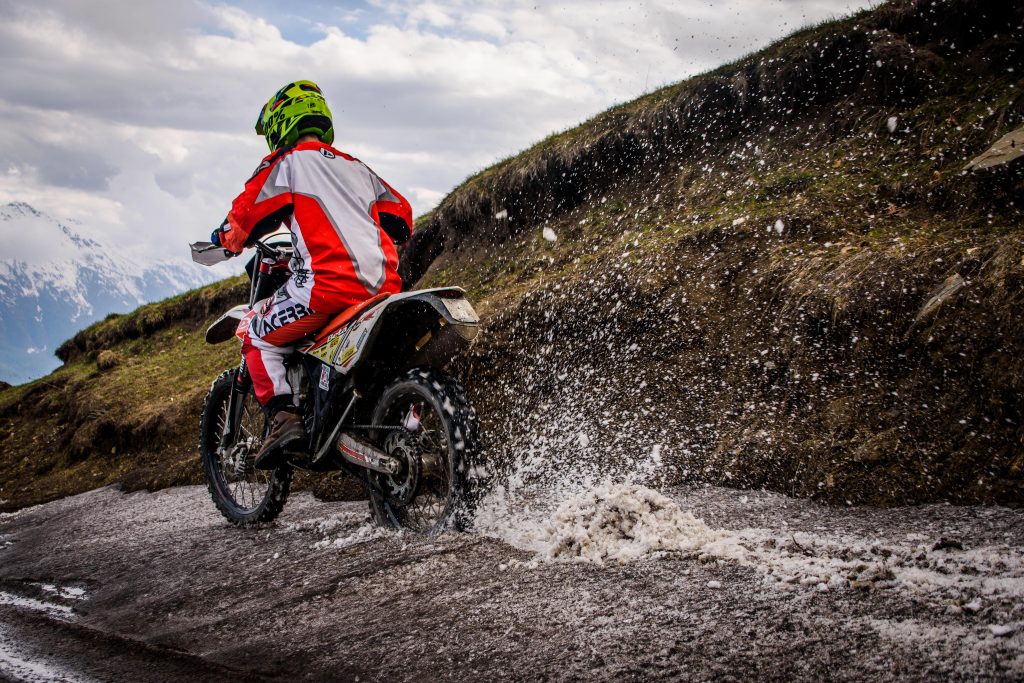 A man on a dirt bike drifting in the snow