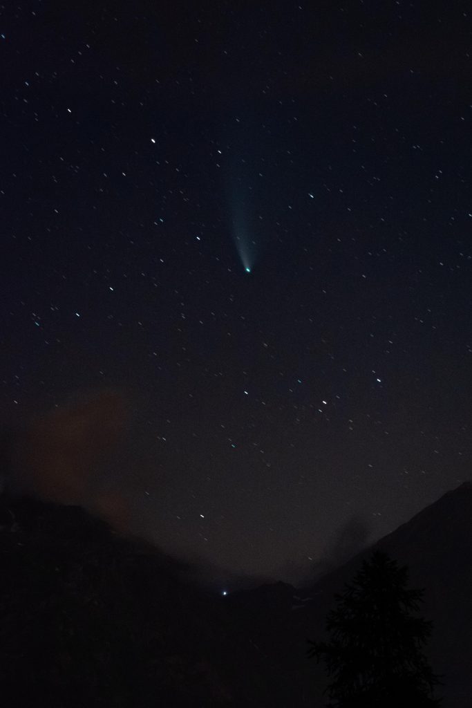 A comet in front of a starry night