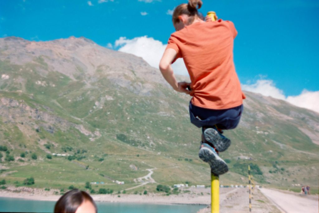 A guy climbing a pole with mountains in the background