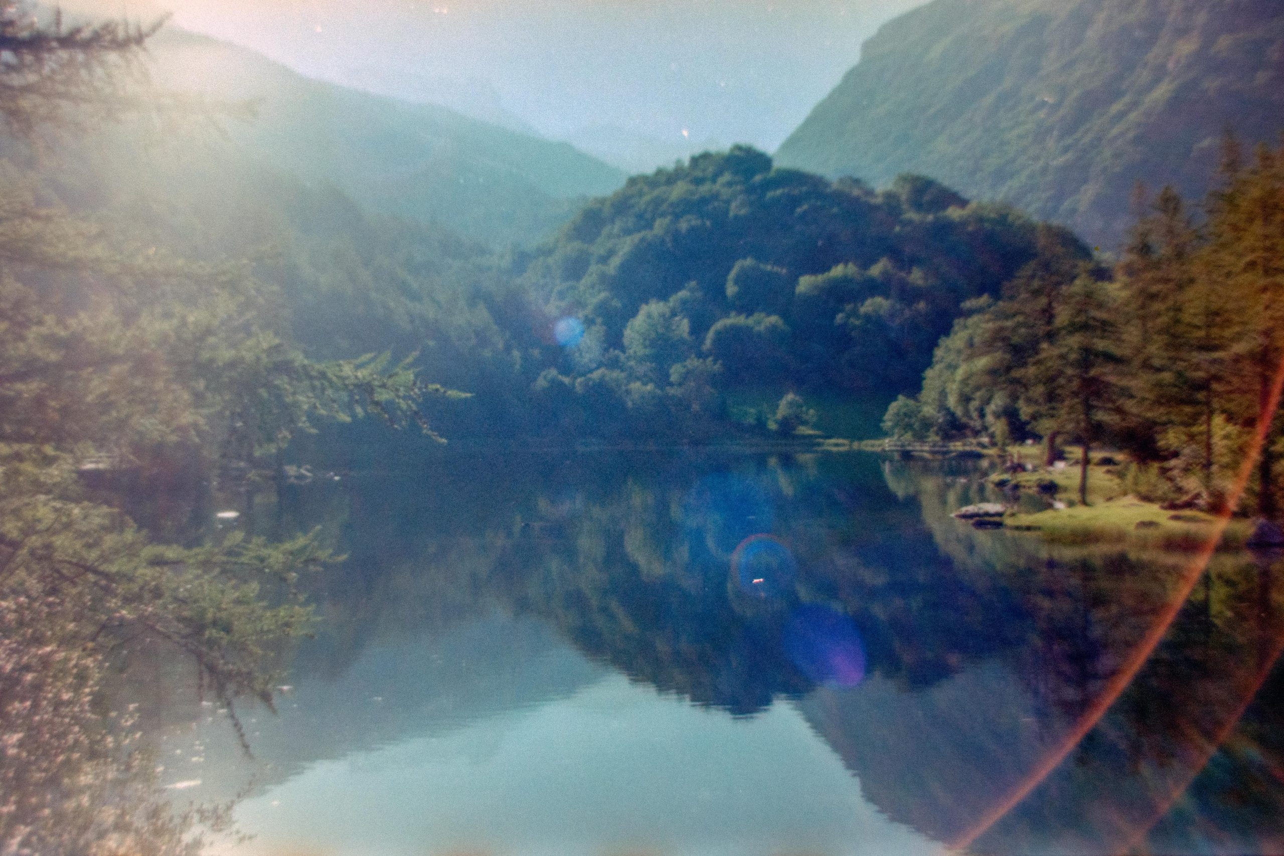 A landscape of a lake between mountains and trees