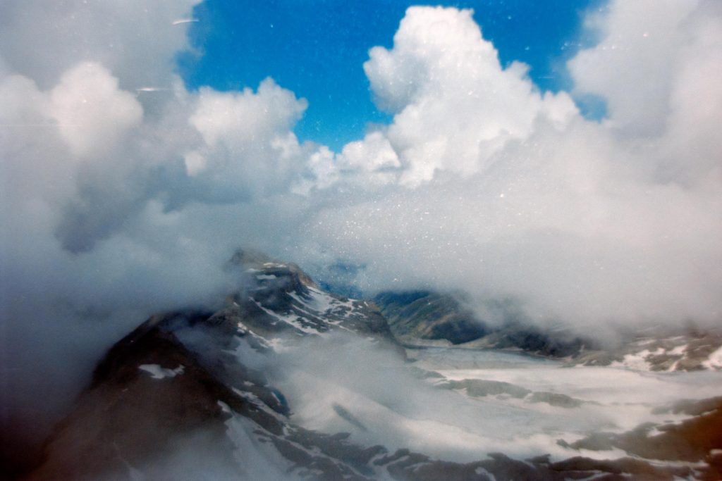 clouds over a mountain with a glacier on its side