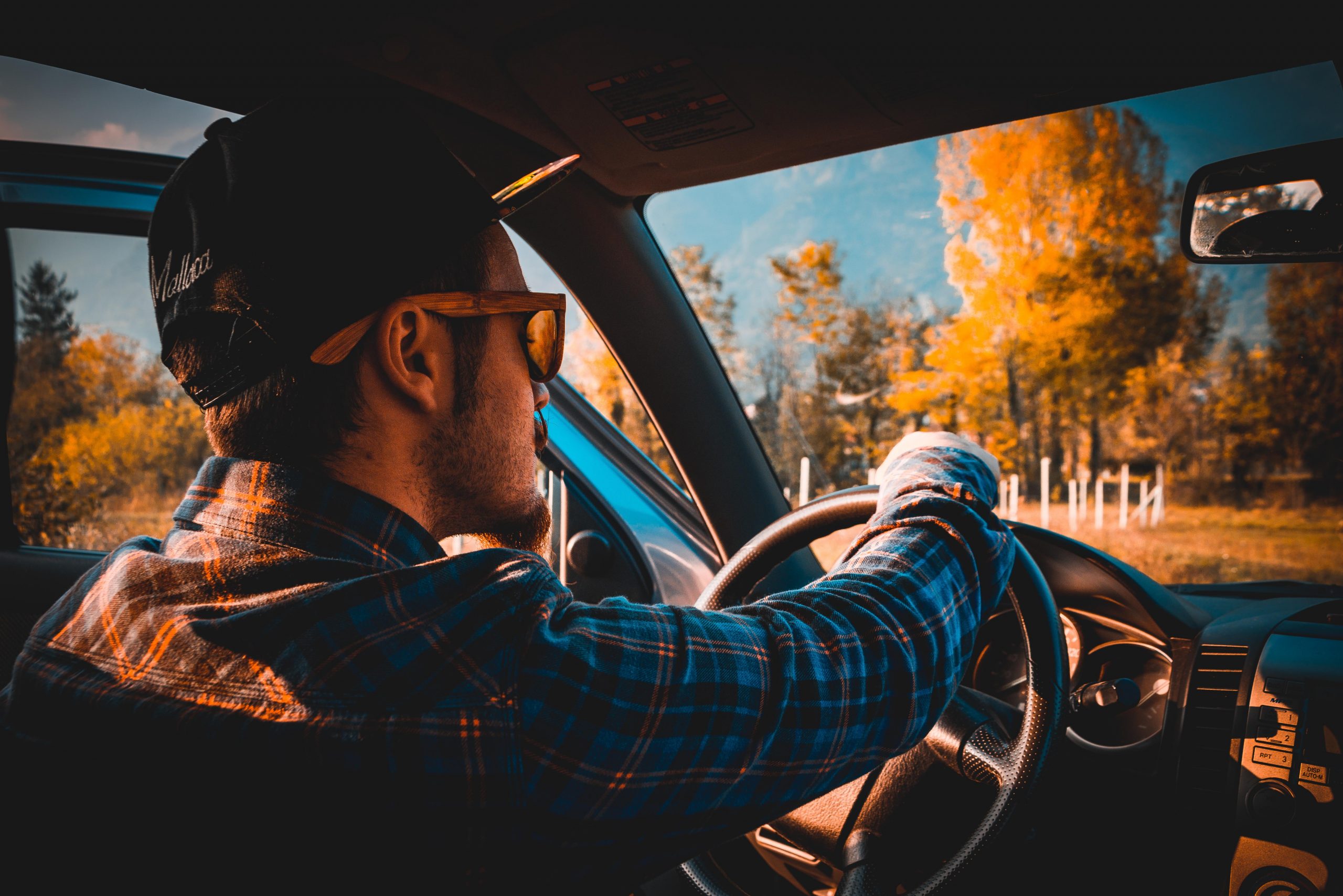 A guy holding a steering wheel inside a car