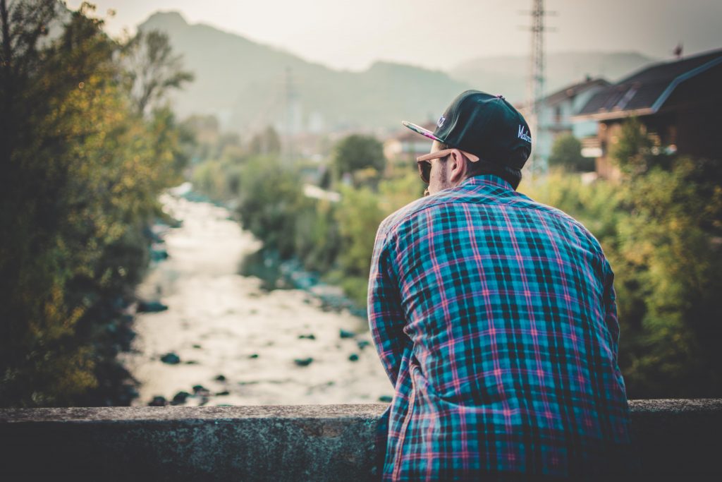 A guy with a flannel looking at a river